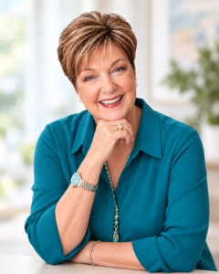 Susan Bock - hand resting on chin teal shirt